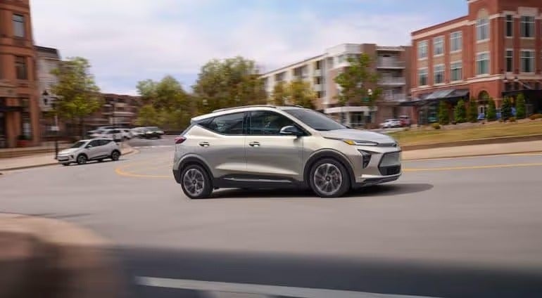 A silver 2022 Chevy Bolt EUV is shown driving on a city street.