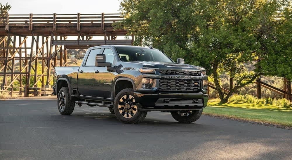 A black 2020 Chevy Silverado 2500HD, popular among Chevy trucks, is parked in front of a wooden bridge near Bethlehem, PA.