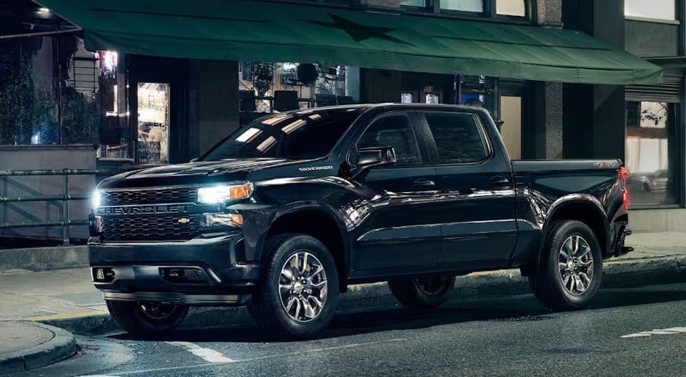 A black 2020 Chevy Silverado 1500, that has a leveling kit, is parked on the side of a city street near Bethlehem, PA, at night.